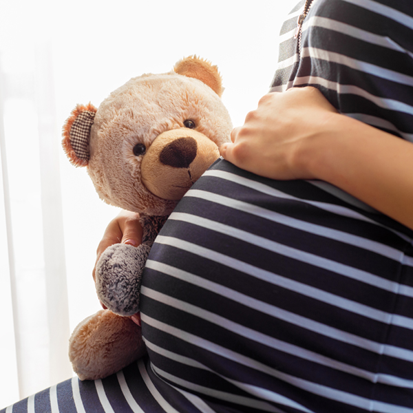 pregnant woman holding teddy bear