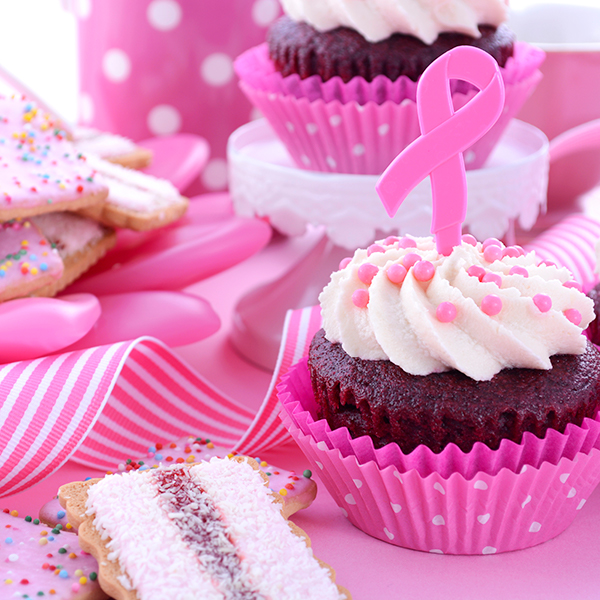 pink cupcakes with decorations and ribbon