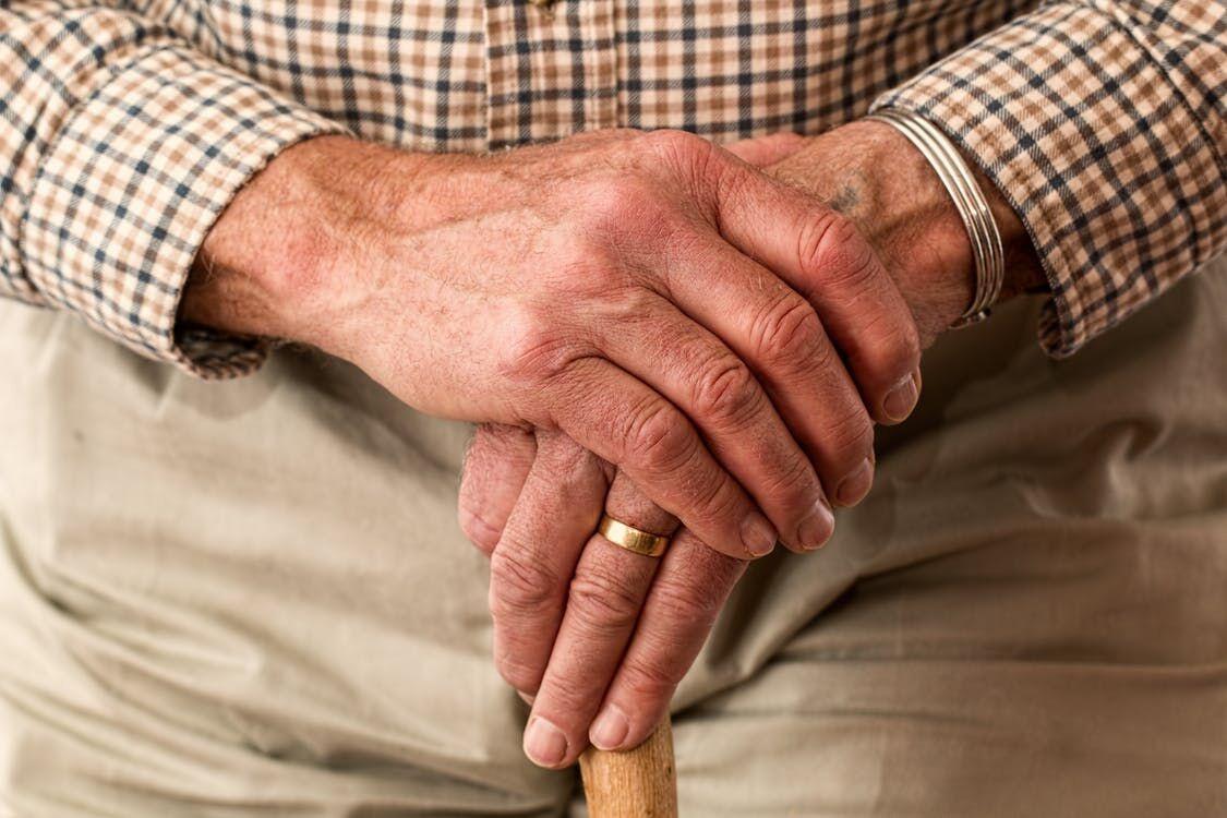 older gentleman with hands resting on top of cane