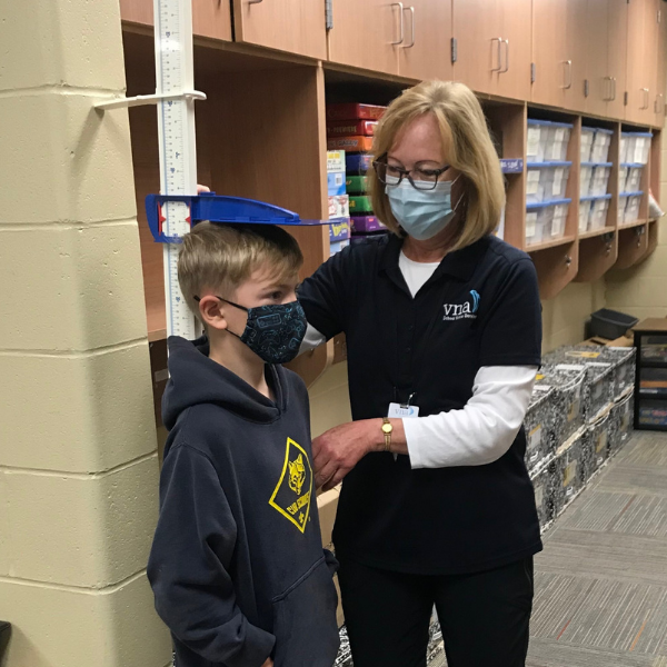 VNA school nurse measuring student