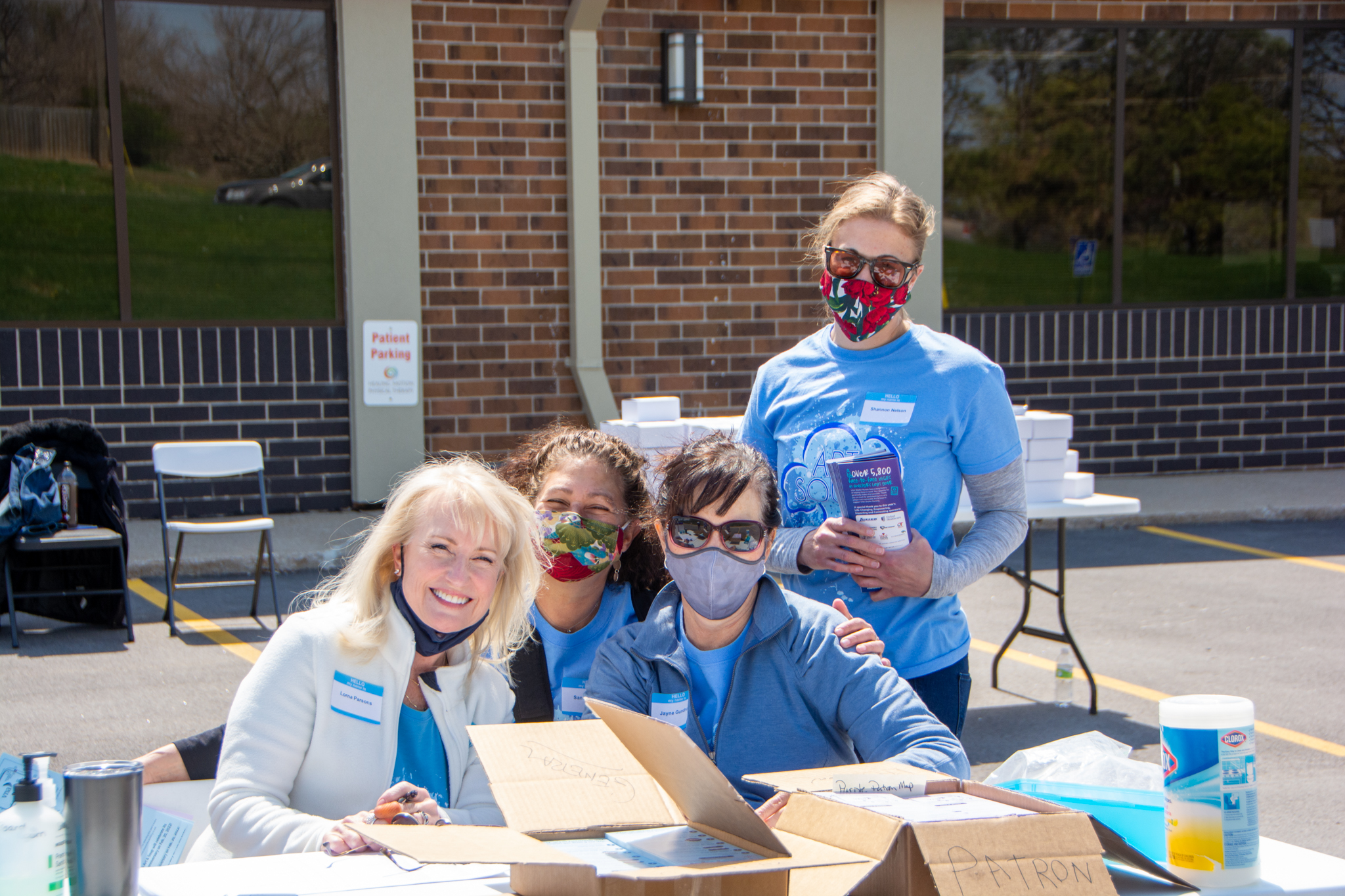 Art & Soup volunteers with masks at volunteer table outside of VNA's office