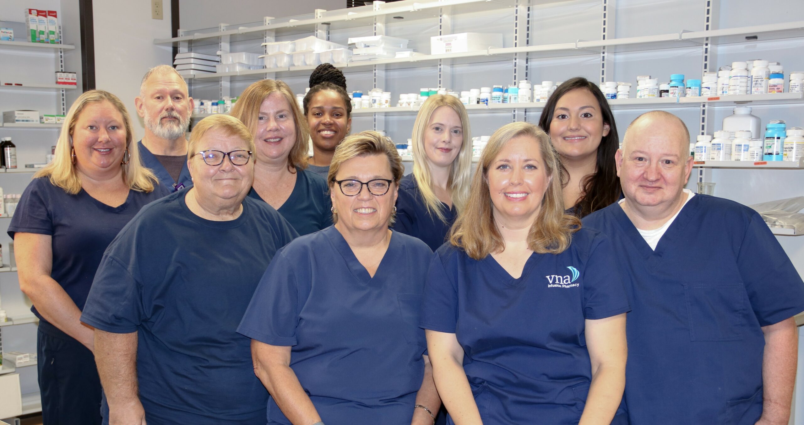 VNA pharmacy staff in scrubs smiling at camera