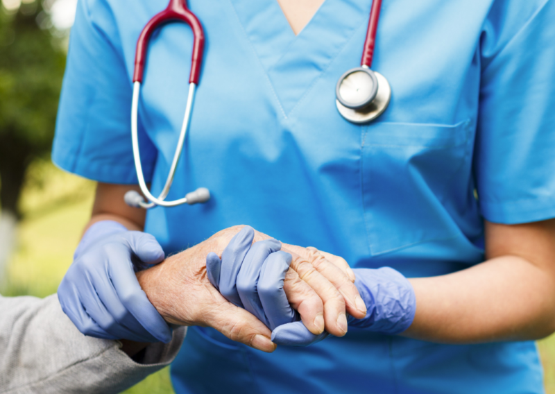 Nurse holding hand of elderly patient