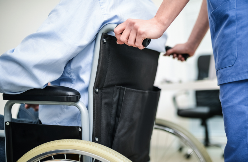 Nurse pushing man in a wheelchair