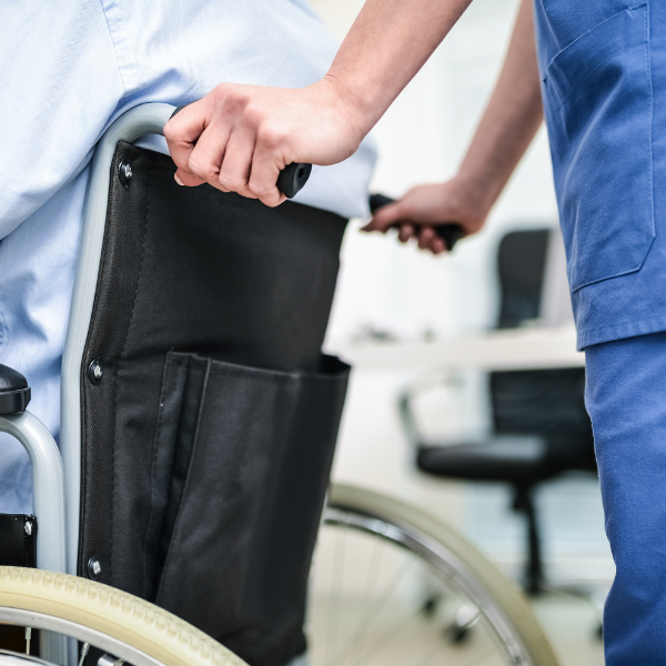 Nurse pushing man in a wheelchair-square